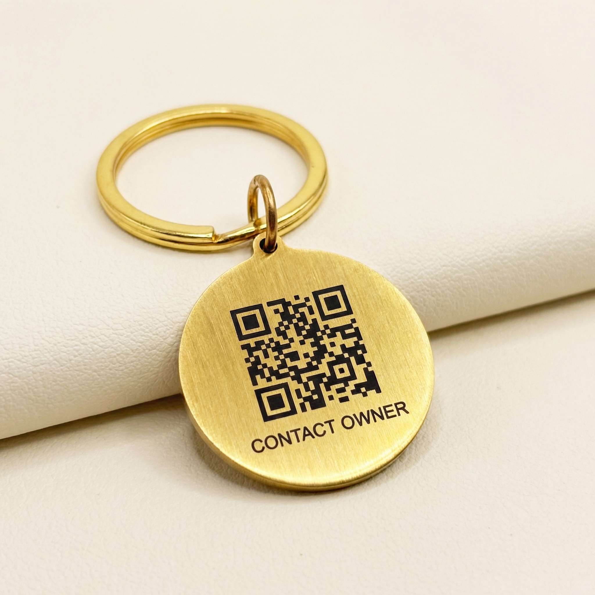 Macro close-up of the LessWorry metal pet tag showing laser engraving quality